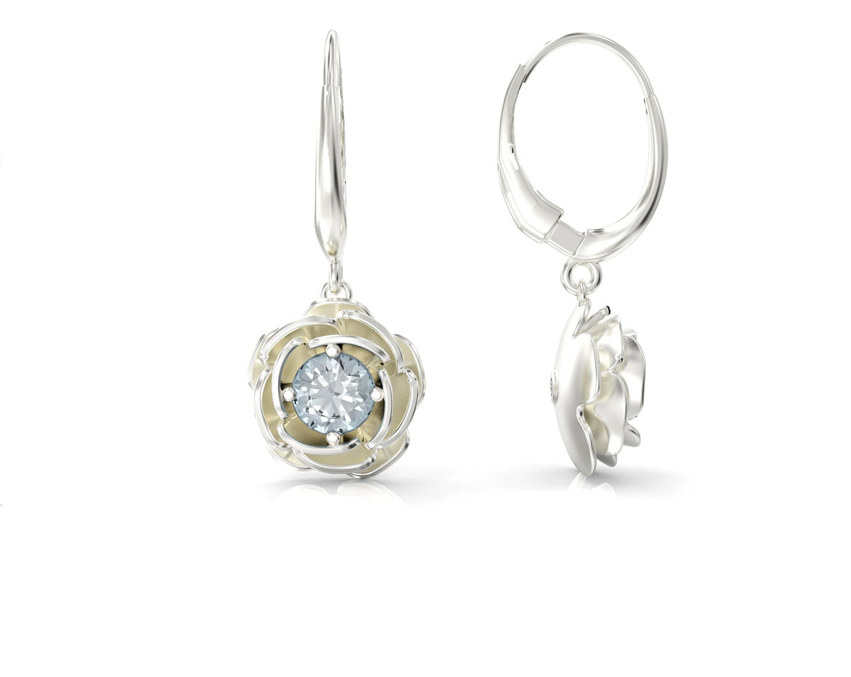 Gold earrings hanging from a rose