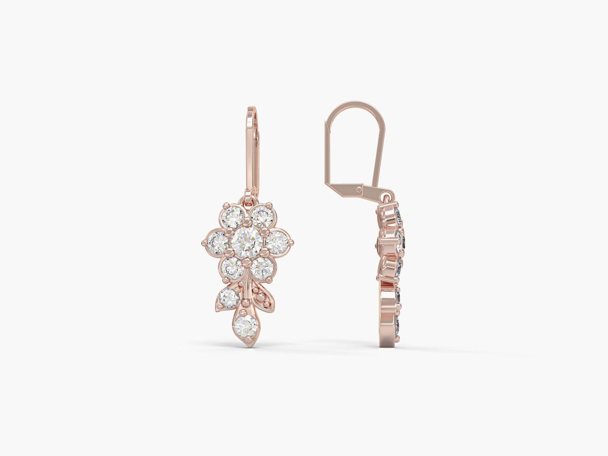 Gold earrings hang from a short flowering branch