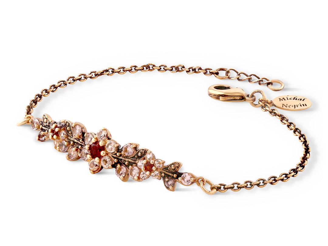 A long flowering branch bracelet studded with cream and garnet crystal stones
