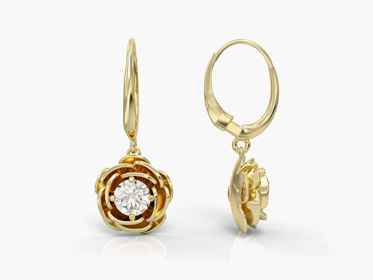 Gold earrings hanging from a rose