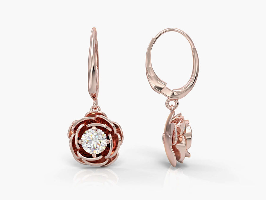Gold earrings hanging from a rose
