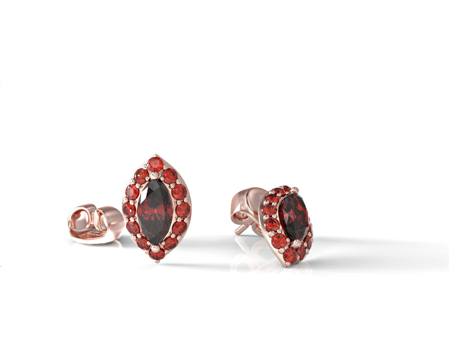 Close-up gold earrings with eyes studded with ruby crystal stones 1