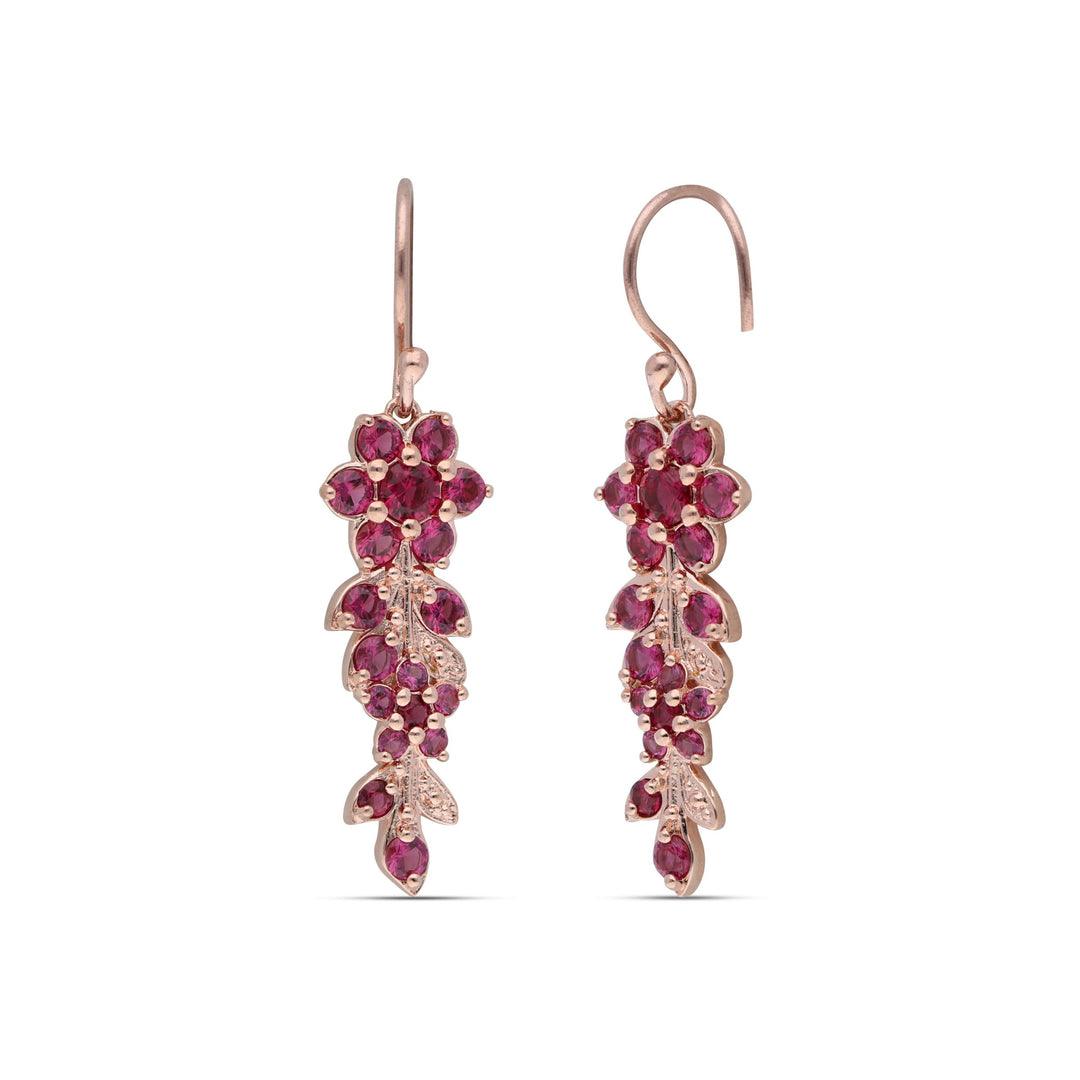 Earrings hanging from a long flowering branch studded with ruby ​​colored crystal stones