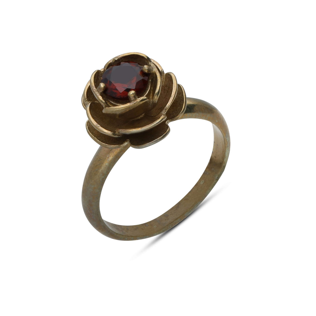A rose ring inlaid with a garnet-colored crystal stone